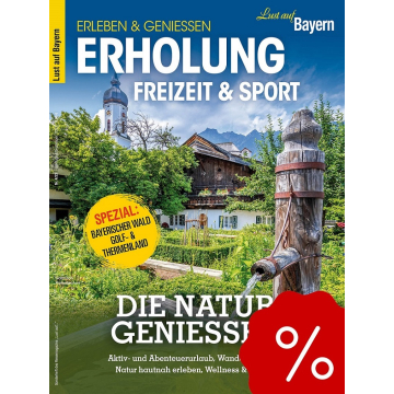 Bayerische Landschaft mit traditionellem Holzbrunnen, altem Haus und Kirchturm im Hintergrund, Text über Erholung und Freizeit in Bayern.
