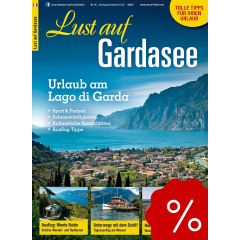 Berglandschaft mit See, Boot und Holzsteg, Titel 'Lust auf S&uuml;dtirol', Text zu Genussregion und Ausflugstipps, rotes Prozentzeichen unten rechts.